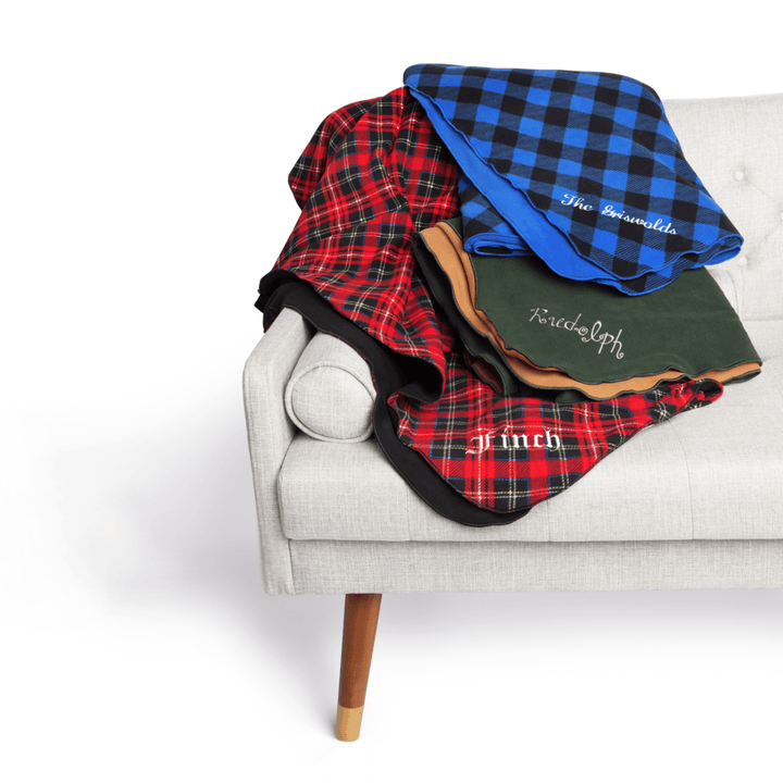 A stack of multicolored blankets on a white coutch