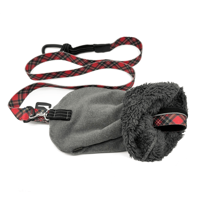 A charcoal leash mitten with a red plaid dog leash attached to it in front of a white background