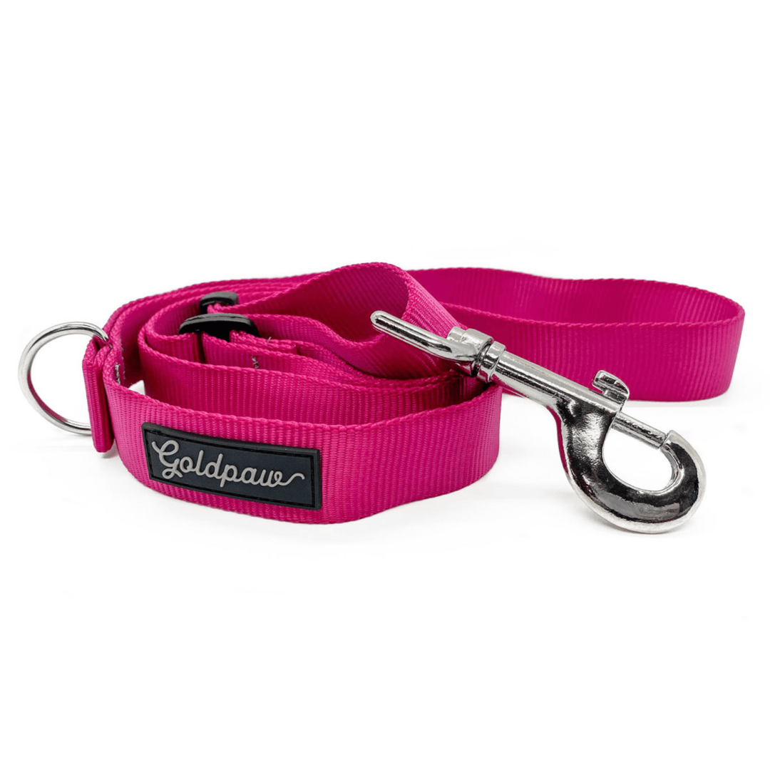 A pink adjustable leash in front of a white background