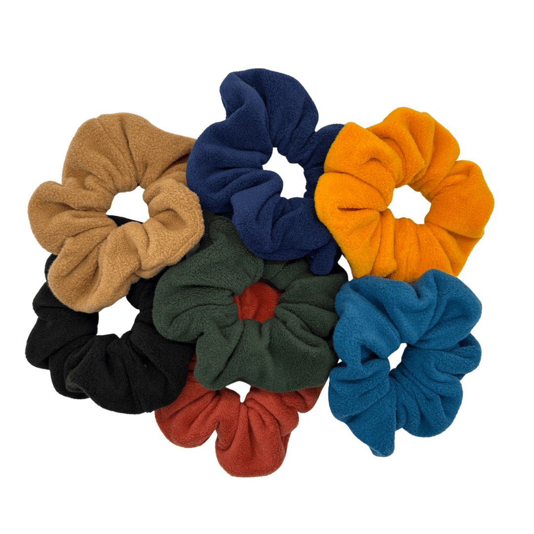 A pile of multicolored scrunchies in front of a white background