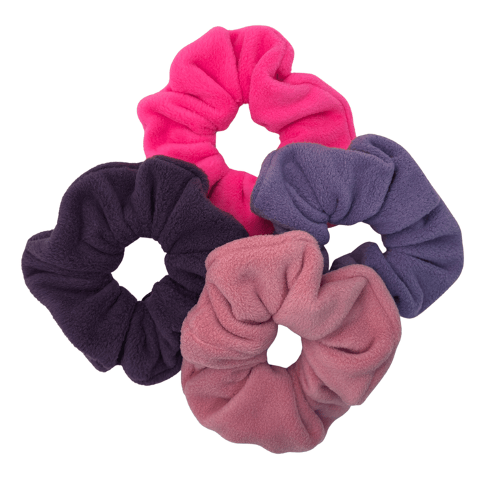 A pile of multicolored scrunchies in front of a white background