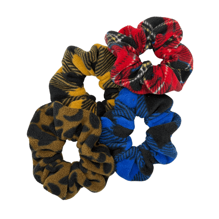 A pile of patterned multicolor scrunchies in front of a white background